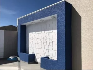 Aplicação de textura de parede em ambiente moderno, mostrando acabamento elegante e sofisticado em sala de estar.