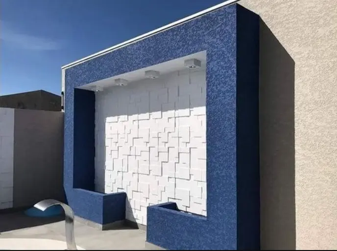 Aplicação de textura de parede em ambiente moderno, mostrando acabamento elegante e sofisticado em sala de estar.